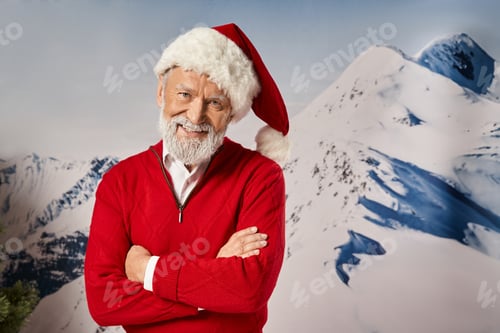 Preview: cheerful man in Santa costume smiling at camera with his arms crossed on chest, winter concept