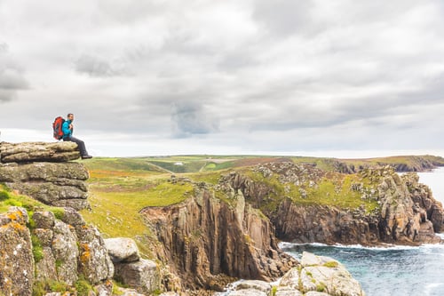 Preview: Man sitting on a rock cliff enjoying the view