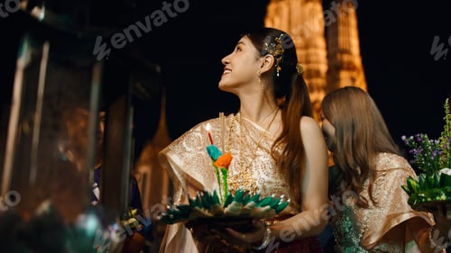 Preview: Thai woman celebrating loi krathong festival, holding kratong with lit candle