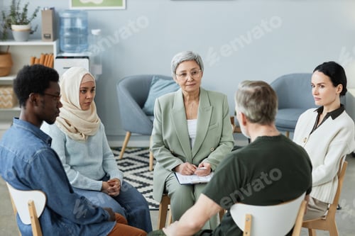 Preview: Confident mature female counselor consulting people with psychological problems