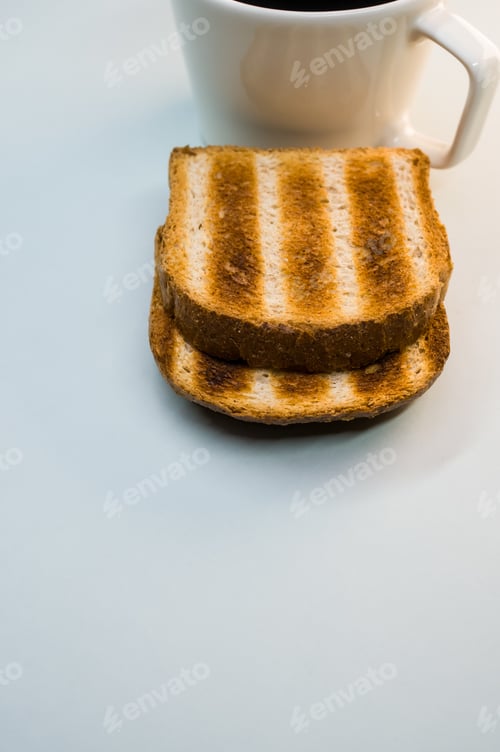 Preview: Vertical shot of toasts and a cup of coffee on a white surface