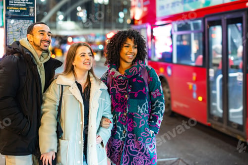 Preview: Diverse friends walking city streets at night in London