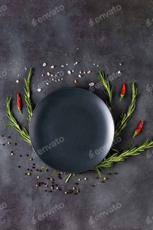 Preview: Empty black plate with rosemary branches and spices on a dark background.