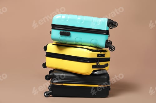 Preview: Stack of colorful suitcases on beige background