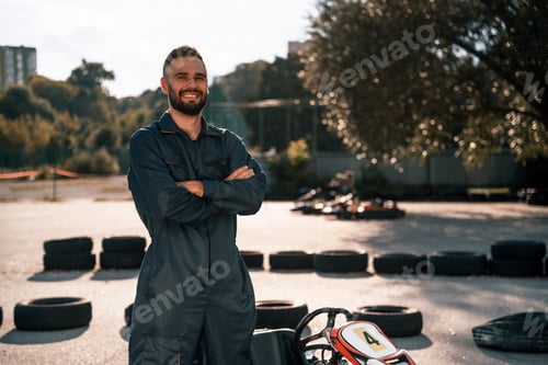 Preview: Smiling Mechanic Poses near Go-Kart Track