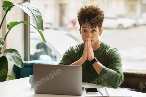 Preview: Portrait of pensive young black guy entrepreneur working at cafe