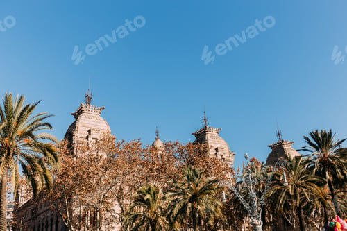 Preview: old building with towers behind green trees, barcelona, spain
