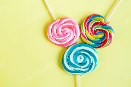 Preview: Colorful lollipops and different colored round candy. Top view.