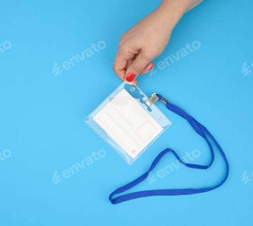 Preview: Female hand holds transparent plastic badge on a blue lanyard on a blue background