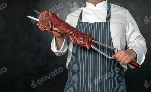 Preview: Faceless chef holding skewers with meat