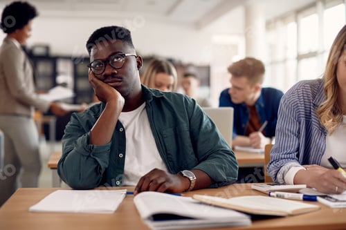 Preview: Black male student feeling bored during class at the university.