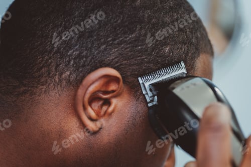 Preview: African American man at home giving himself a hair cut with clippers