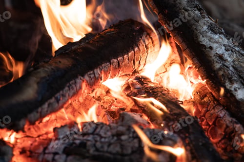 Preview: Macro close up of orange flames of a fire with burning charcoal logs embers timber burning alight