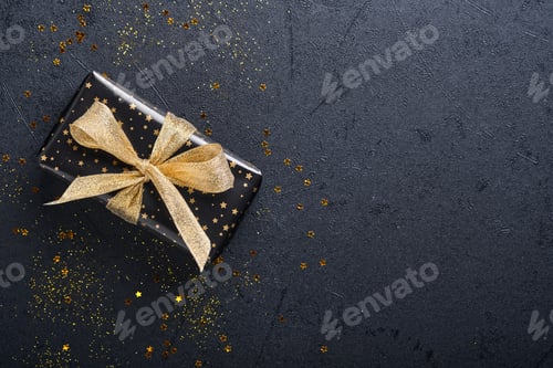 Preview: Wrapped Gift with Gold Bow on Dark Background