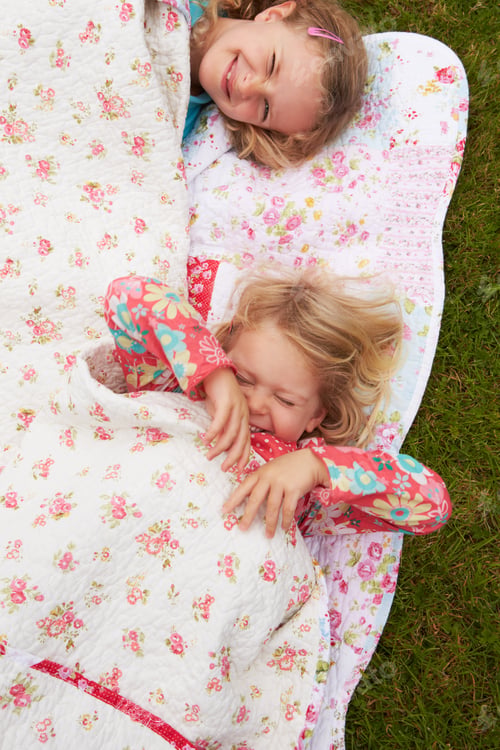 Preview: Two Girls Lying Under Blanket On Camping Holiday