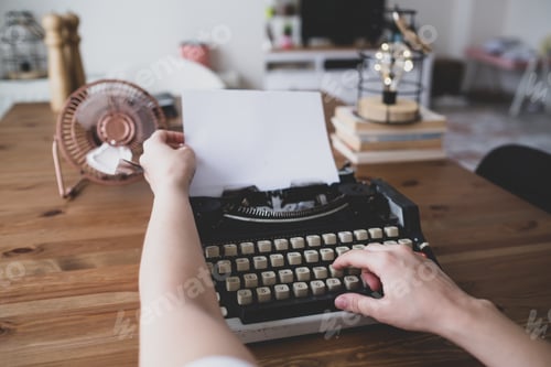 Preview: writes book with old typewriter on wooden table. vintage fan and bulb decor. retro decor home.