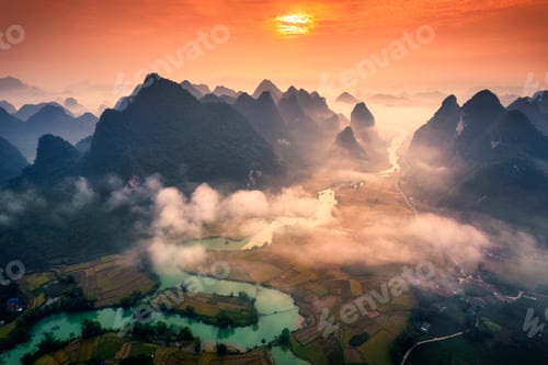 Preview: Sunrise over mountain range with foggy on rural village and river flows through in Phong Nam Valley