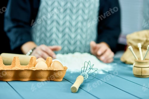 Preview: Man forming the dough on a floured surface and kneading it with his hands.
