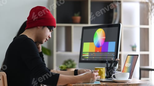 Preview: Team of graphic designer working in creative office.