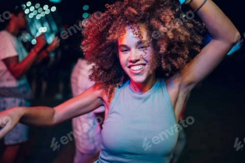 Preview: Young woman dancing with afro hair at night party