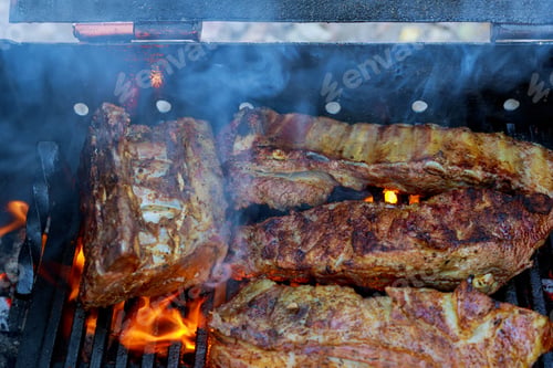 Preview: bbq pork ribs cooking on flaming grill shot with selective focus pork ribs on the grill