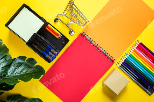 Preview: Layout of multi-colored stationery on a yellow background: spiral notebook,