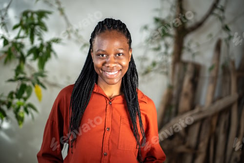 Preview: Satisfied confident black young woman with toothy smile looking at camera posing indoors with plants
