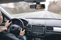 Preview: Woman driver's hands on a car steering wheel.