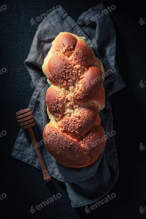 Preview: Homemade and sweet golden challah on dark table for breakfast.