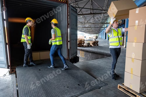 Preview: Worker carry carton box taken from 40 feet steel container on the trailer truck park at warehouse