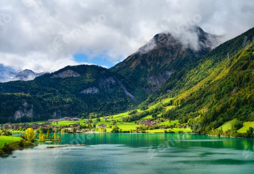 Preview: Lungern, canton of Obwalden, Switzerland. A view of rural homes in a green meadow.