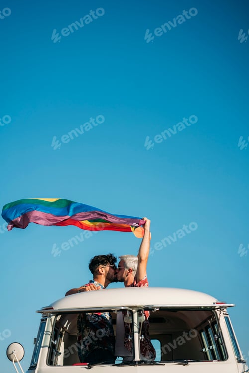 Preview: Kissing gay couple holding LGBT flag