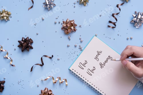 Preview: New year, new dreams motivation phrase with female hand on bright festive background