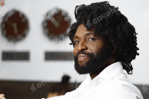 Preview: Portrait of african american businessman standing in hotel lobby