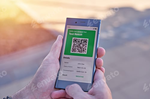 Preview: Man holding smartphone displaying on app mobile negative COVID-19 express test results, closeup