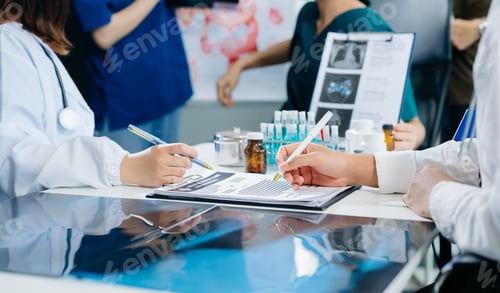 Visualização: Equipe médica se reunindo com médicos em jalecos brancos e esfoliantes cirúrgicos sentados em uma mesa