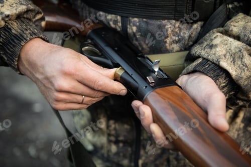 Preview: Close-up of a hunter hands loading his shotgun