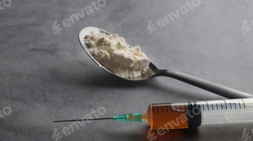 Preview: Spoon with powder and syringe on light grey table, closeup. Hard drugs