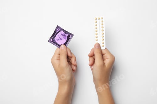 Preview: Woman holding condom and birth control pills on white background, top view. Safe sex