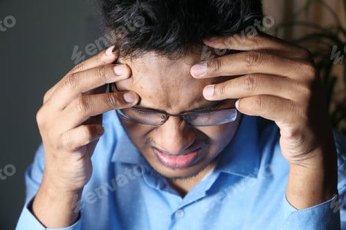 Preview: Young man suffering headache, close up