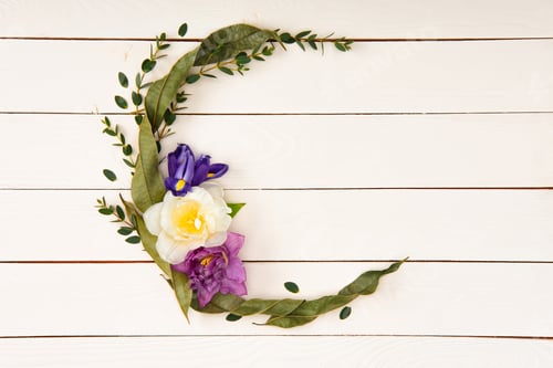 Preview: top view of beautiful floral wreath with leaves and flowers on wooden surface