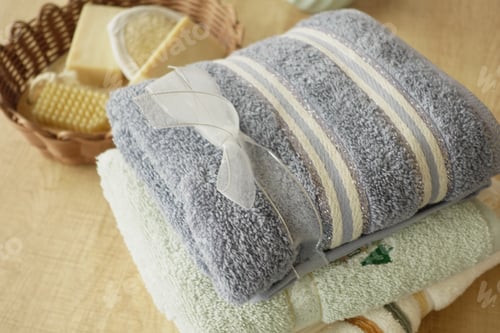 Preview: Soft towels and natural skincare products arranged on a wooden table