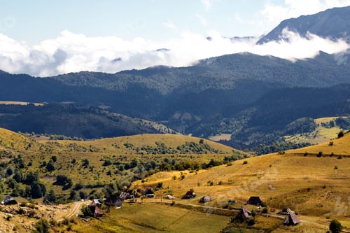 Preview: Aerial shot of mountainous landscape with plato tops under white clouds in blue sky