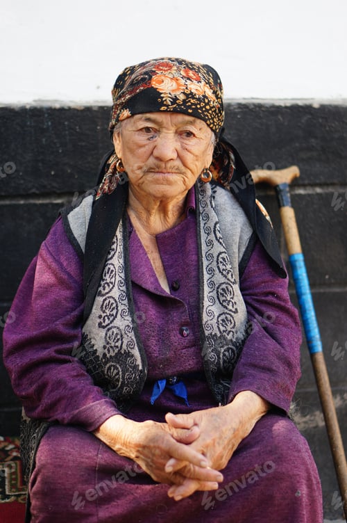 Preview: Grandma is sitting in front of the house wall
