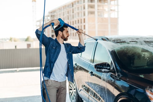 Preview: Man washing car with pressure washer at self service station