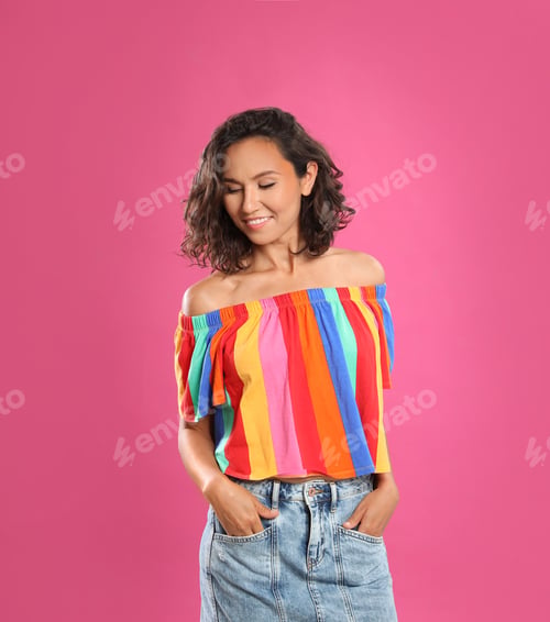 Preview: Happy young woman in casual outfit on pink background