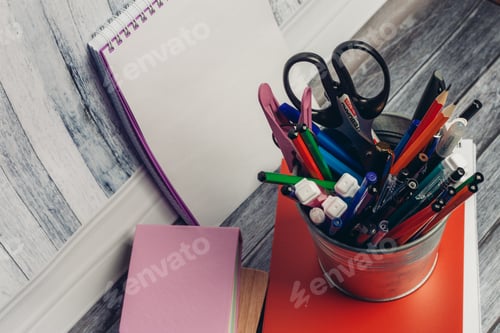 Preview: mug with stationery on notepad and wooden table in office