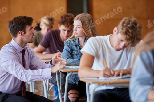 Preview: Teenage Students Sitting Examination With Teacher Invigilating