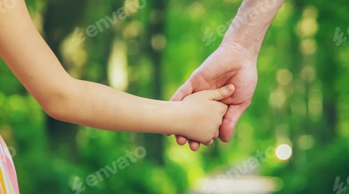 Preview: Father and child go holding hand. Selective focus.