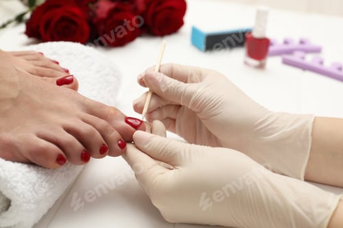 Preview: Pedicurist working with client`s toenails in beauty salon, closeup